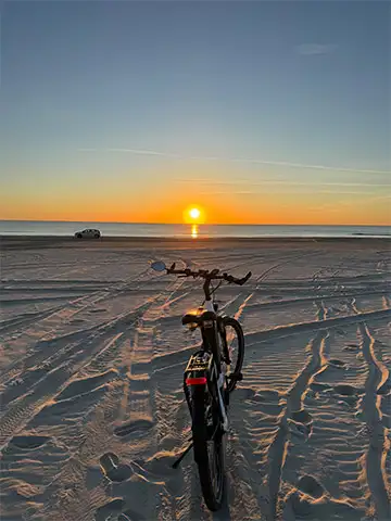 JobRad am Strand mit Sonnenuntergang